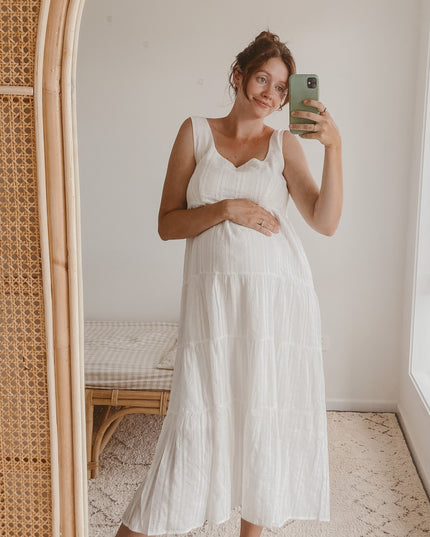Maternity fit of the white square neck sleeveless tiered midi dress, showing a comfortable and flowing silhouette.