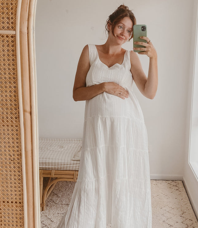 Maternity fit of the white square neck sleeveless tiered midi dress, showing a comfortable and flowing silhouette.