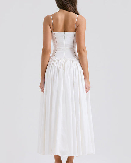 Back view of women's white square neck sleeveless midi dress, highlighting the fitted waist and pleated skirt, with green heels.