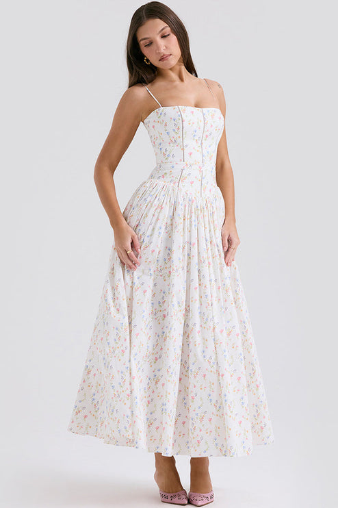 Front view of women's white floral square neck midi dress, showcasing the colorful small flower print and pleated skirt, with pink heels.