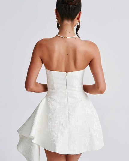 Back view of a white floral strapless mini dress, showing the zipper closure and draped skirt detail.