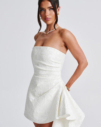 Side angle of the white floral strapless mini dress, showcasing the elegant drape of the skirt and fitted bodice.