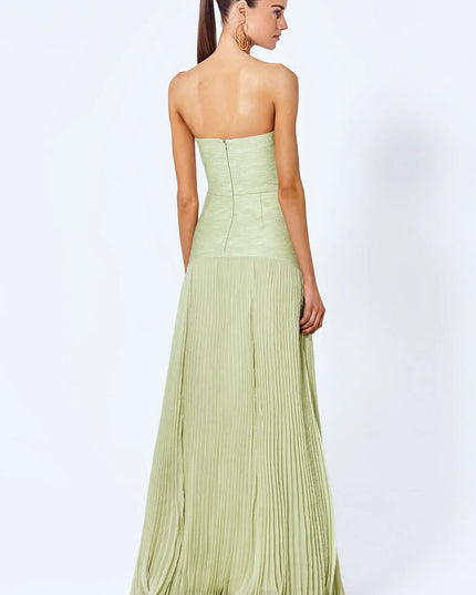 Back view of a women's light green strapless pleated maxi dress showing the flowing skirt and back zipper closure.
