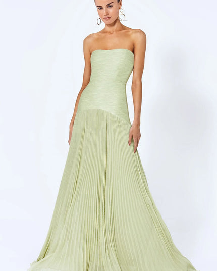 Full-length view of a women's formal strapless pleated maxi dress in a light sage green color, flowing skirt.