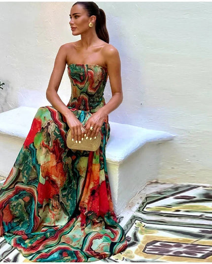 Side view of a woman wearing a strapless printed maxi dress with a gold clutch, highlighting the dress's full skirt.