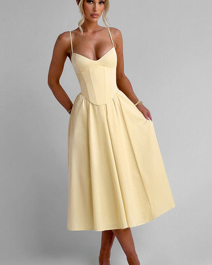 Front view of a light yellow sweetheart corset midi dress with spaghetti straps and a flowing skirt, paired with light heels.