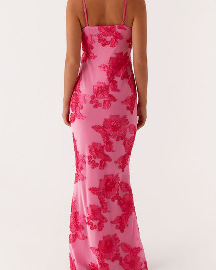 Back view of a women's pink floral maxi dress featuring intricate embroidered flowers and thin shoulder straps.