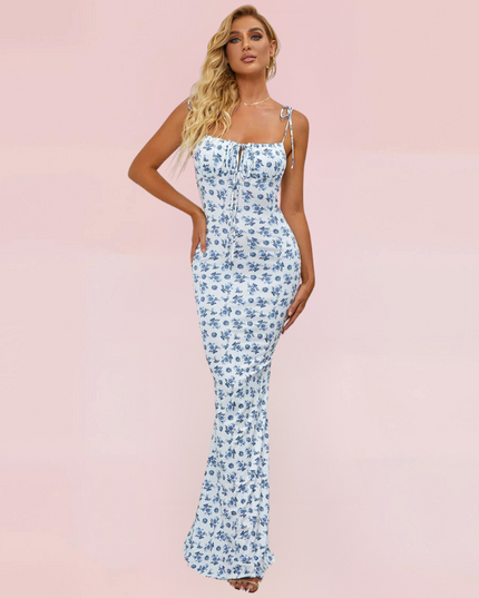 Front view of women's sleeveless maxi dress in white with blue floral pattern and tie-up straps