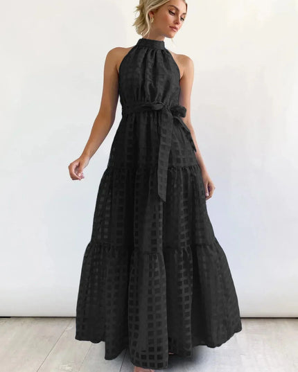 Elegant black halter neck tiered maxi dress, featuring a subtle checkered pattern and a matching waist tie.