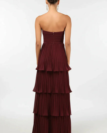 Back view of the women's burgundy strapless tiered pleated maxi dress, showing the full skirt and zipper detail.