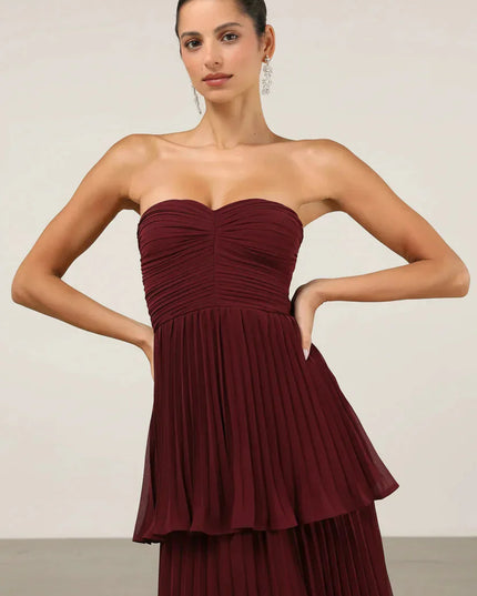 Close-up of the bodice and upper tiers of the burgundy strapless pleated maxi dress, showing fabric texture.