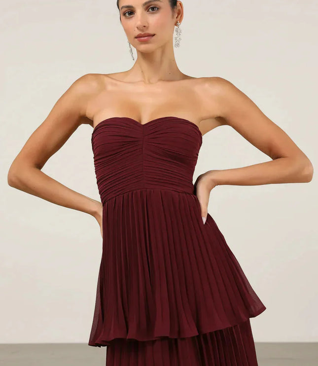 Close-up of the bodice and upper tiers of the burgundy strapless pleated maxi dress, showing fabric texture.