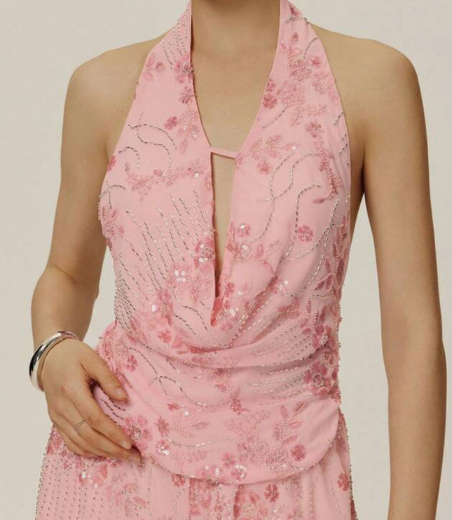 Close-up of a light pink sequin halter top with a deep V-neck and delicate silver embroidery, part of a matching pink outfit.