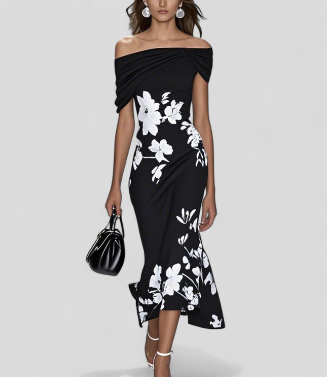 Black off-shoulder midi dress with prominent white floral print and stylish trumpet hem, holding a black handbag.