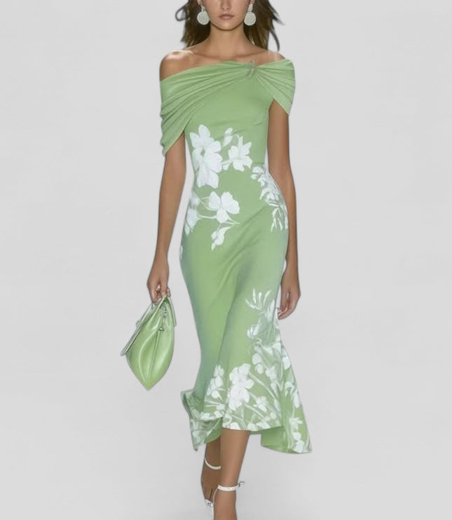 Light green off-shoulder midi dress with white floral print and trumpet hem, carried a matching handbag.