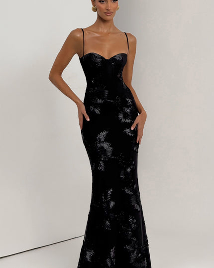 Full-length front view of the black floral lace-up corset maxi dress, highlighting the shimmering floral appliques.
