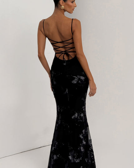 Back view of a black floral maxi dress with delicate spaghetti straps and a criss-cross lace-up corset back.