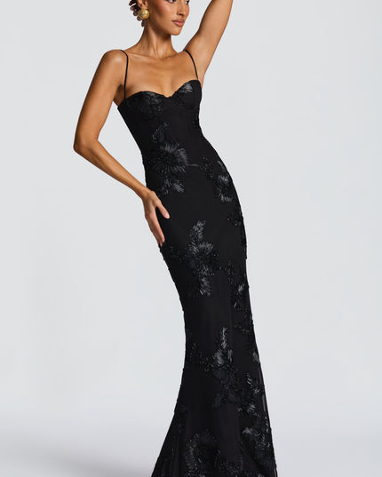 Side profile of a black floral maxi dress with intricate floral appliques and a silhouette, for prom.