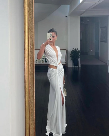 White sleeveless halter V-neck maxi dress with side cut-outs and a high slit, selfie in a mirror.
