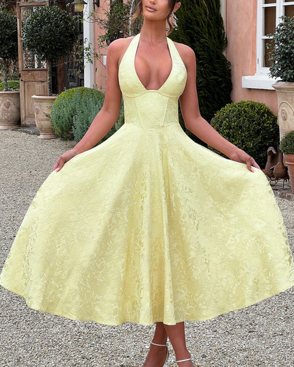 Full-length view of a yellow jacquard halter v-neck midi dress, featuring a textured pattern.