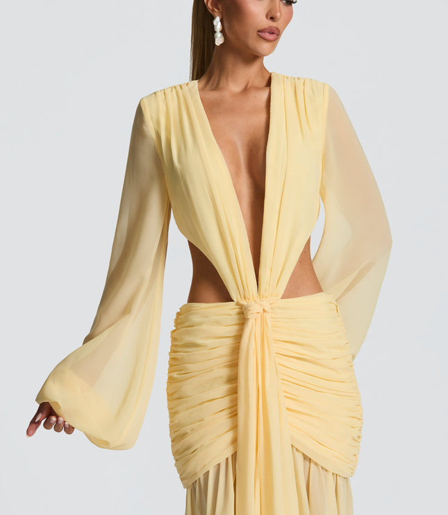 Close-up of the bodice of a light yellow prom maxi dress with deep V-neck, long sheer sleeves, and knotted front.