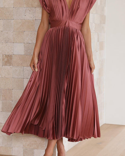 Full length view of a women's rose pleated v-neck midi dress, with the skirt gently fanned out, paired with nude heels.
