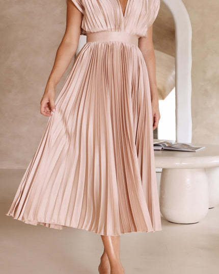 Full length view of a women's light pink pleated v-neck midi dress, showcasing the elegant silhouette and soft fabric.