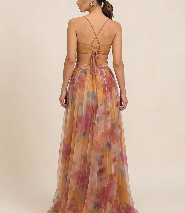 Back view of a women's wedding guest maxi dress with a floral print, criss-cross strap detail, and tie-back closure.