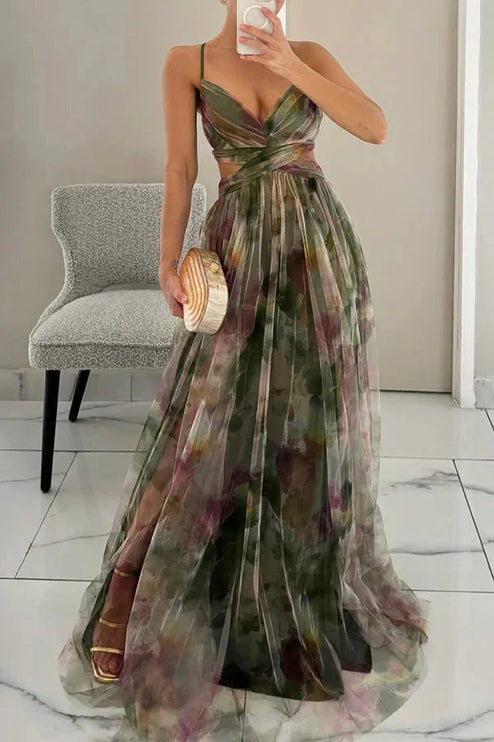 Women's green floral print maxi dress with V-neck and cut-out waist, holding a unique wood-look clutch, for wedding guests.