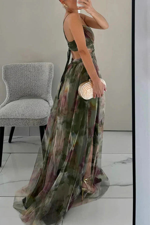 Side view of a women's green floral V-neck sleeveless maxi dress, showing the flowing skirt and back strap details.