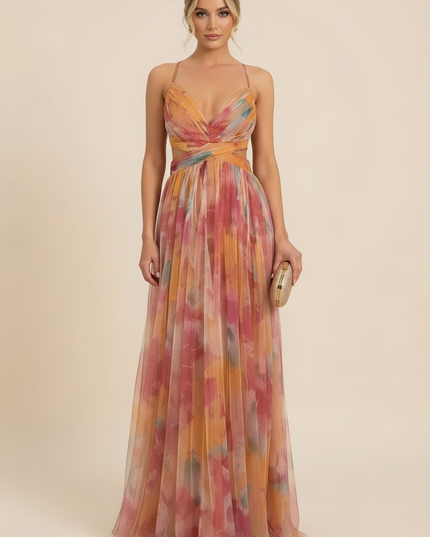Women's wedding guest maxi dress with a colorful floral print, V-neck, and delicate spaghetti straps, holding a gold clutch.