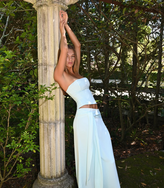 Light blue strapless corset maxi dress side pose showing fitted bodice and wrap skirt tie detail